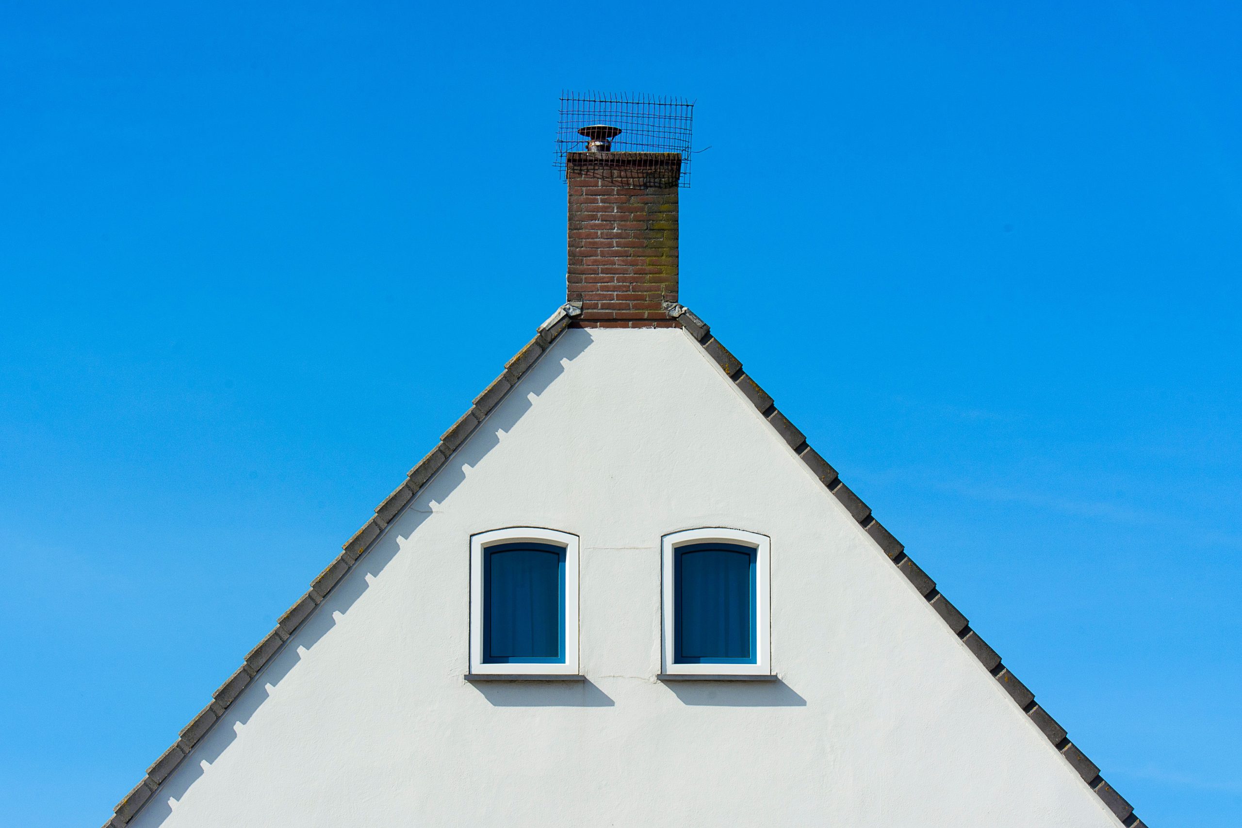 Facade minimaliste maison cheminée ciel bleu