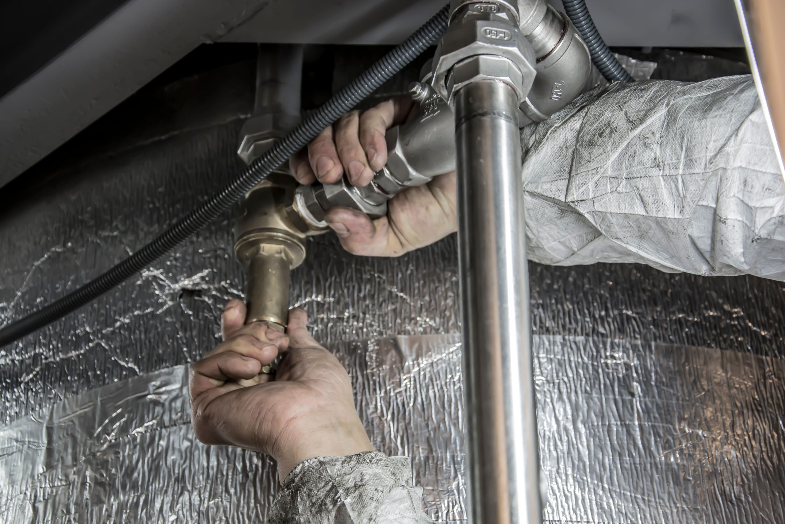 Plombier installant tuyauterie acier professionnellement