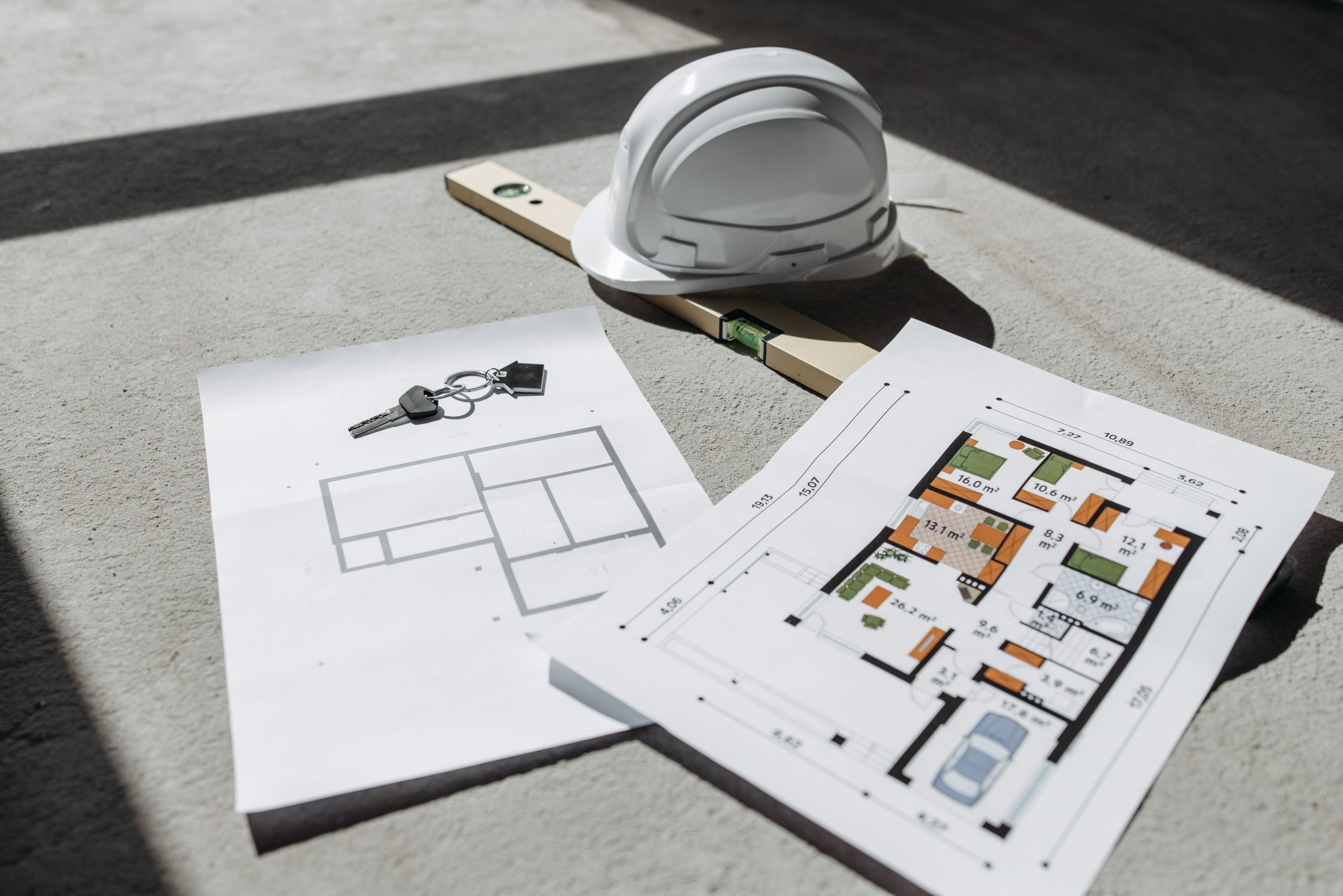 Plans architecturaux avec casque et cles sur sol