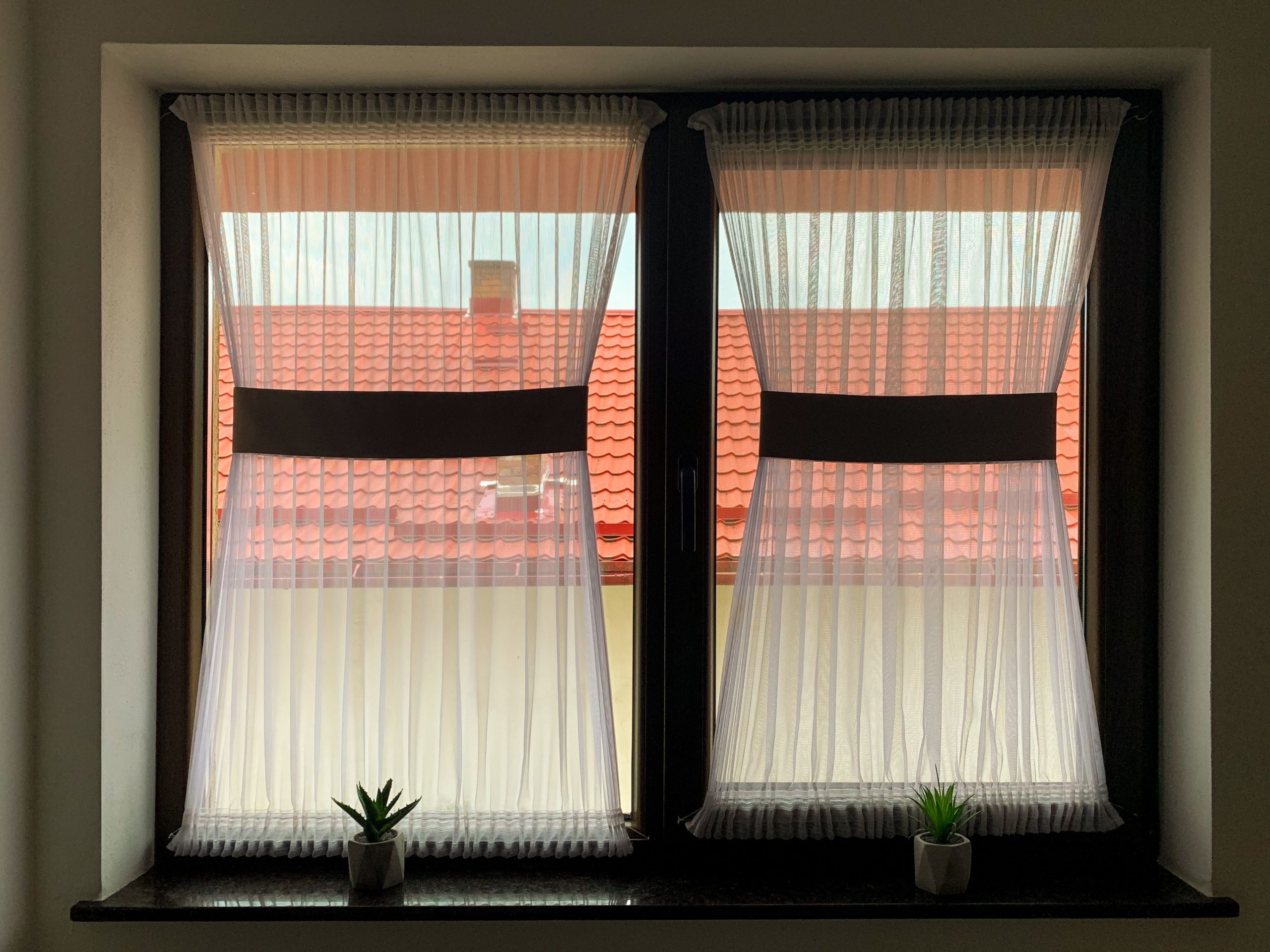 Fenêtre avec voilages blancs et plantes decoration