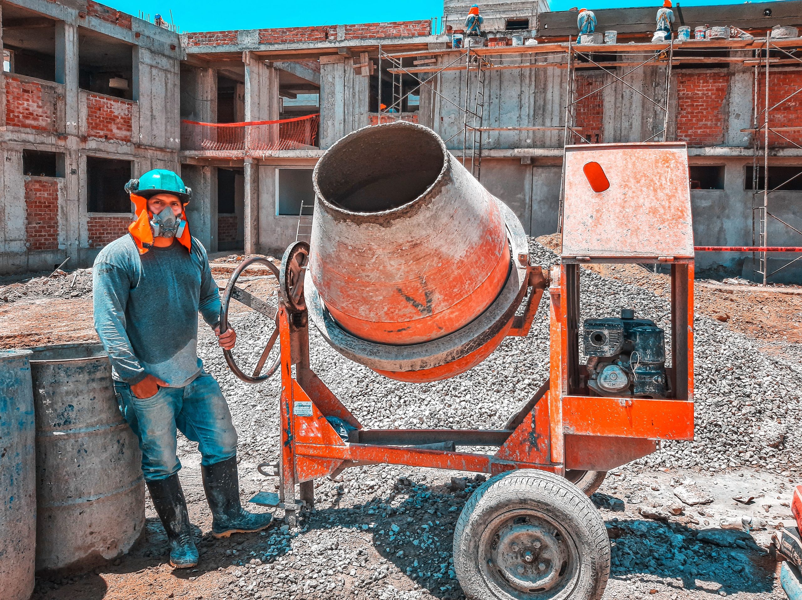 Ouvrier utilisant une bétonnière sur chantier