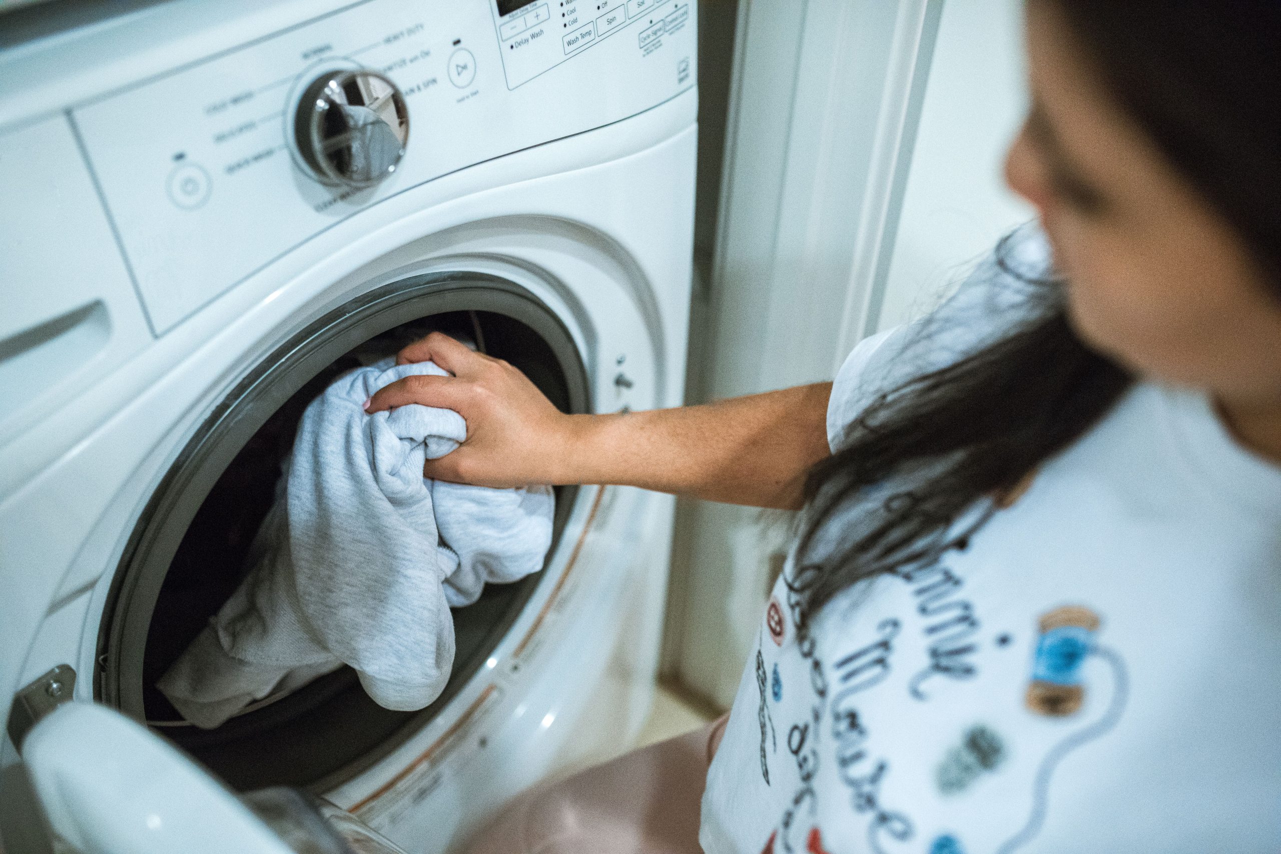 Femme chargeant linge dans machine à laver